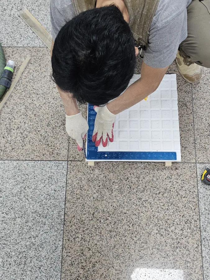 천장 격자 무늬에 맞춰 문짝 마감판을 재단하는 모습